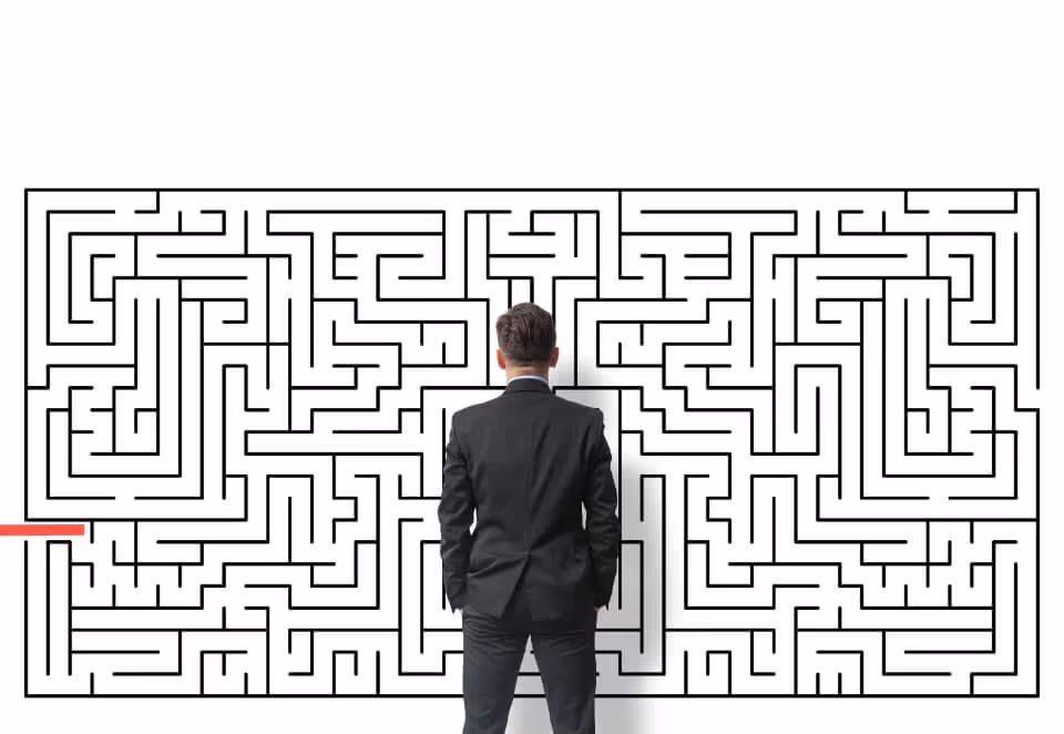 A man in a business suit standing in front of a complex maze, symbolizing the challenges and complexity of handling difficult situations.