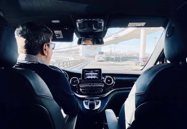 Driving instructor driving himself, picture taken from inside the back seat