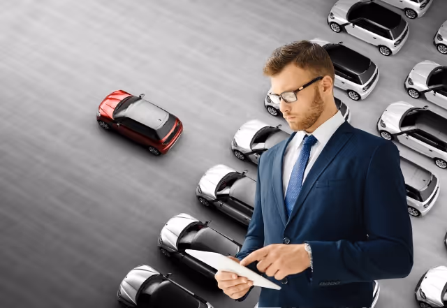 A driving school manager with a fleet of cars in the background